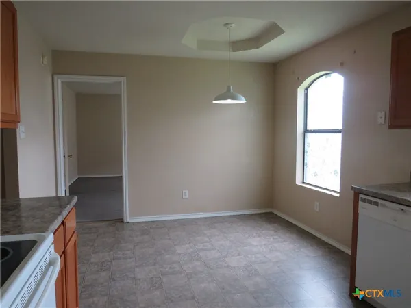 an empty room with windows and cabinet