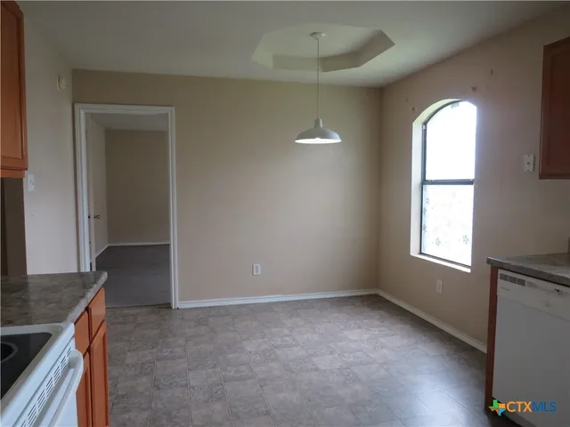 an empty room with windows and cabinet