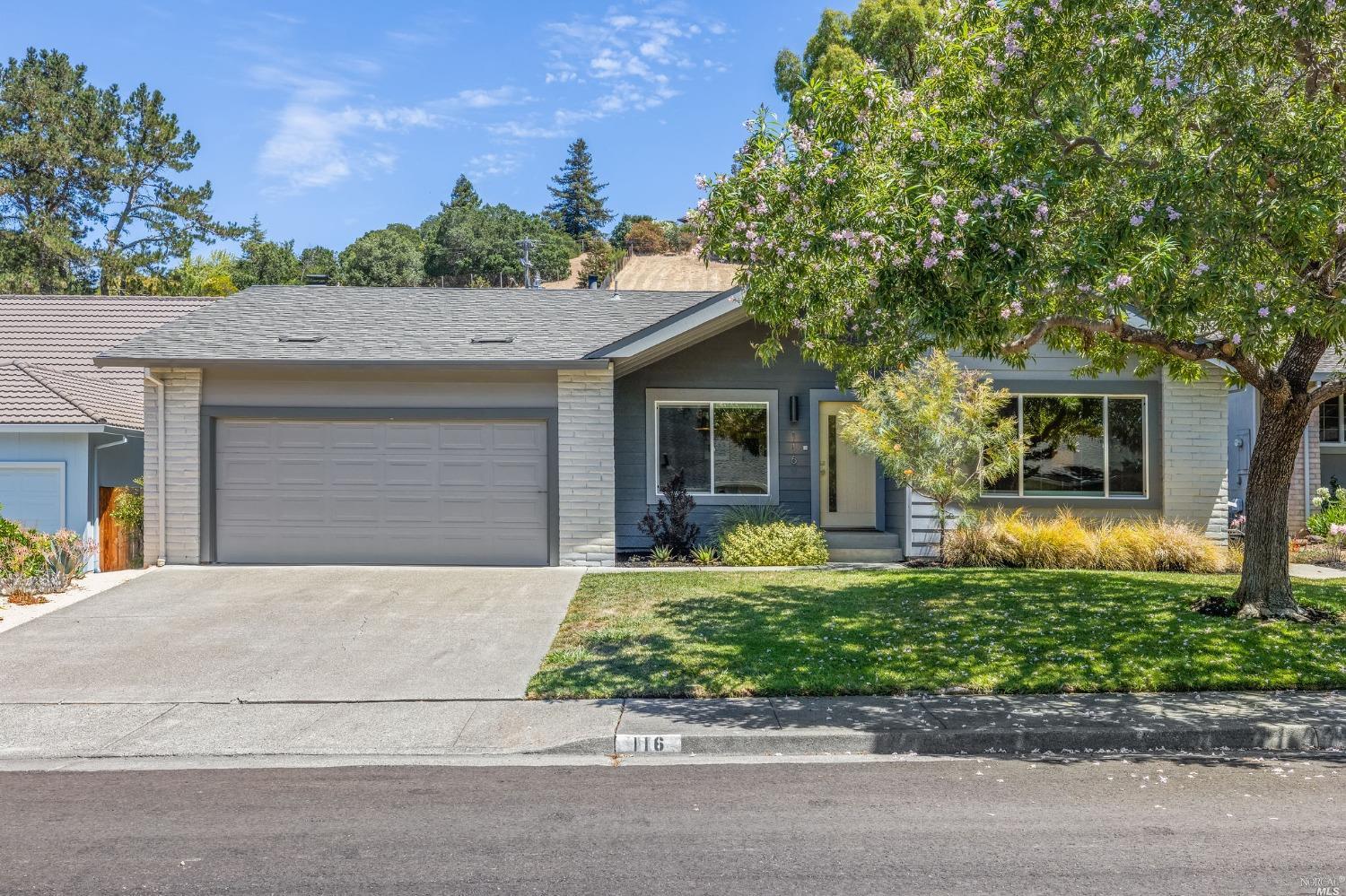 a front view of a house with a yard garage and outdoor seating