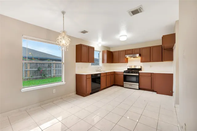 a large kitchen with a large counter top stainless steel appliances and cabinets