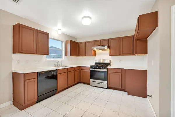 a kitchen with granite countertop a stove top oven sink and cabinets
