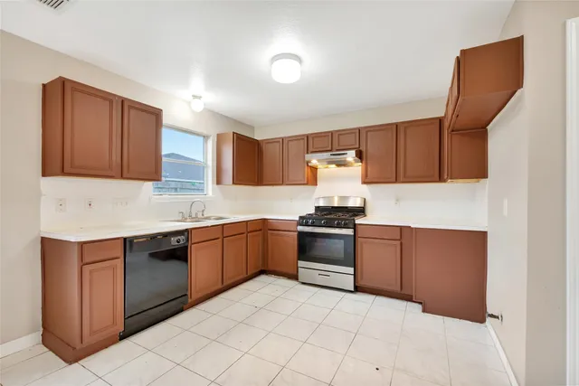 a kitchen with granite countertop a stove top oven sink and cabinets