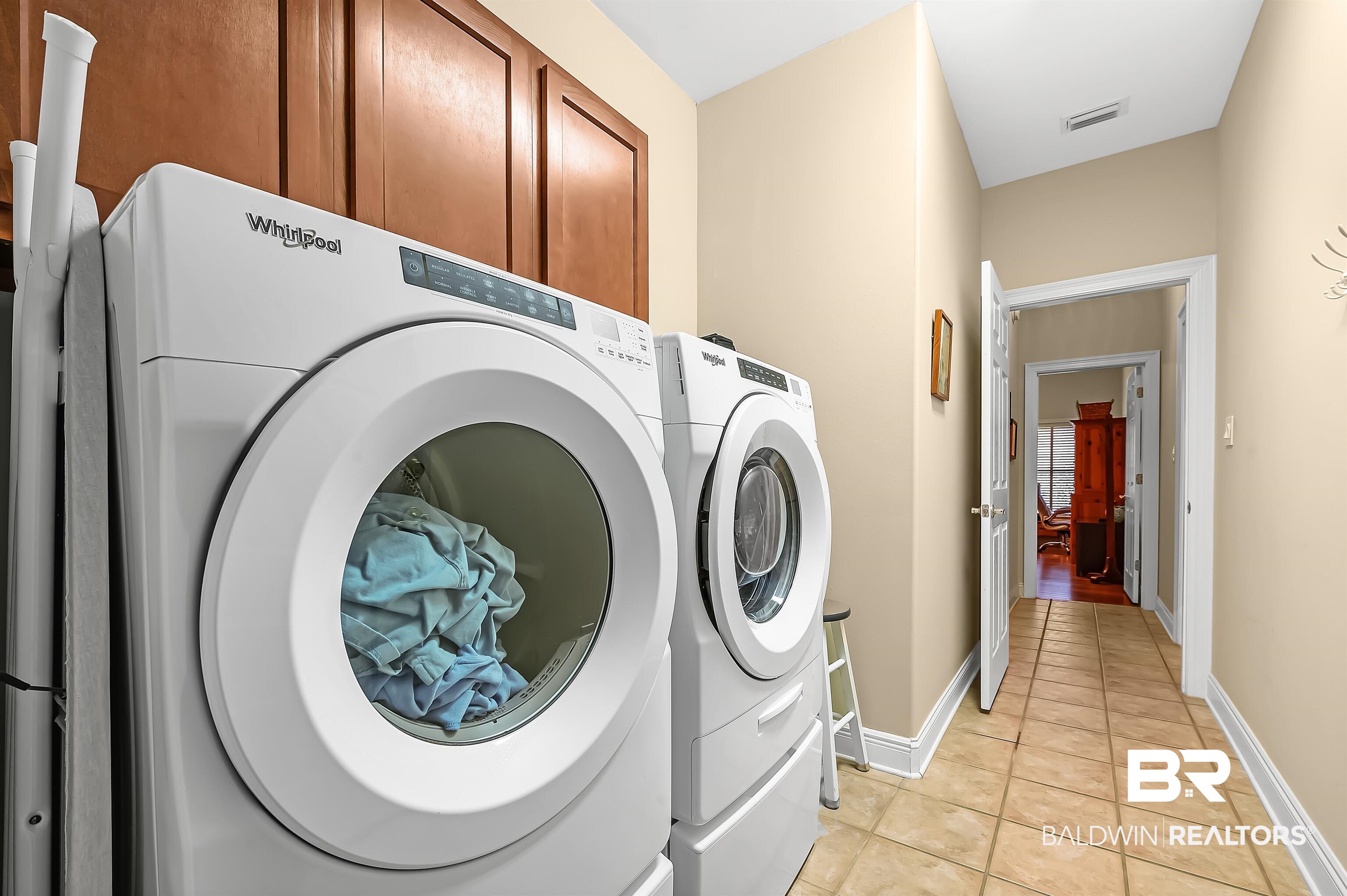 22726 Inverness Way Foley, AL 36535 - Photo 29 of 51 Washroom with washing machine and clothes dryer, light tile patterned floors, and cabinets
