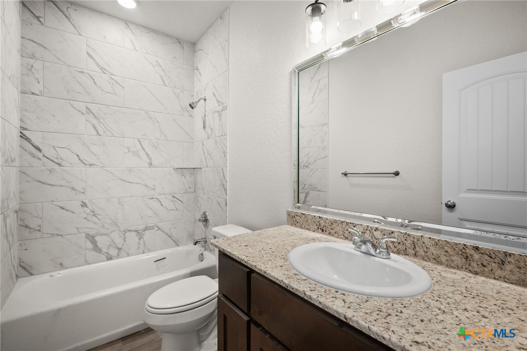 126 Leon Lane Kempner, TX 76539 - Photo 12 of 17 a bathroom with a granite countertop sink toilet mirror and bathtub