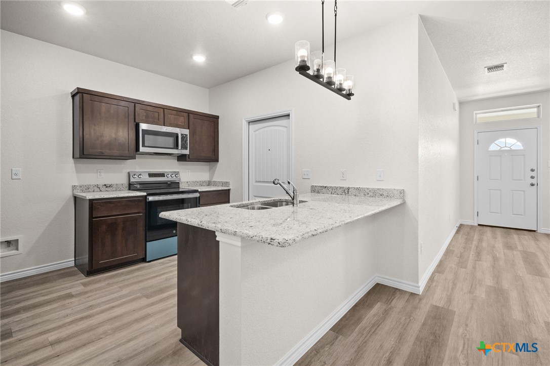 126 Leon Lane Kempner, TX 76539 - Photo 8 of 17 a kitchen with kitchen island granite countertop stainless steel appliances and wooden floor