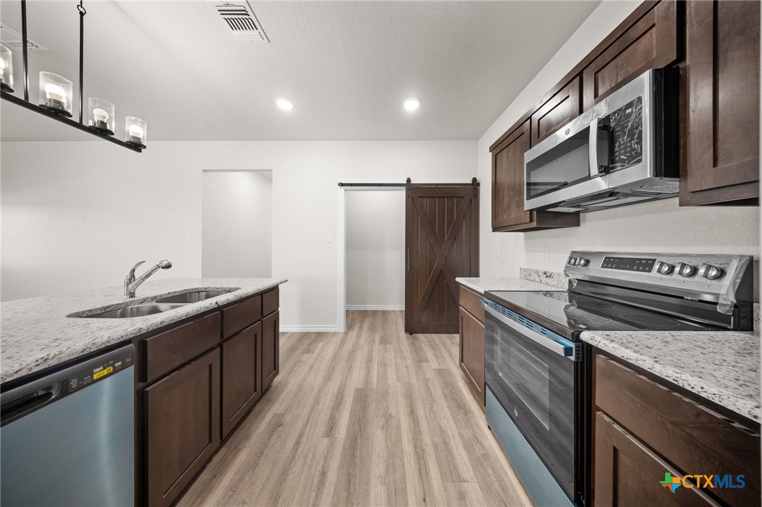 126 Leon Lane Kempner, TX 76539 - Photo 10 of 17 a kitchen with stainless steel appliances granite countertop a refrigerator a stove and a sink