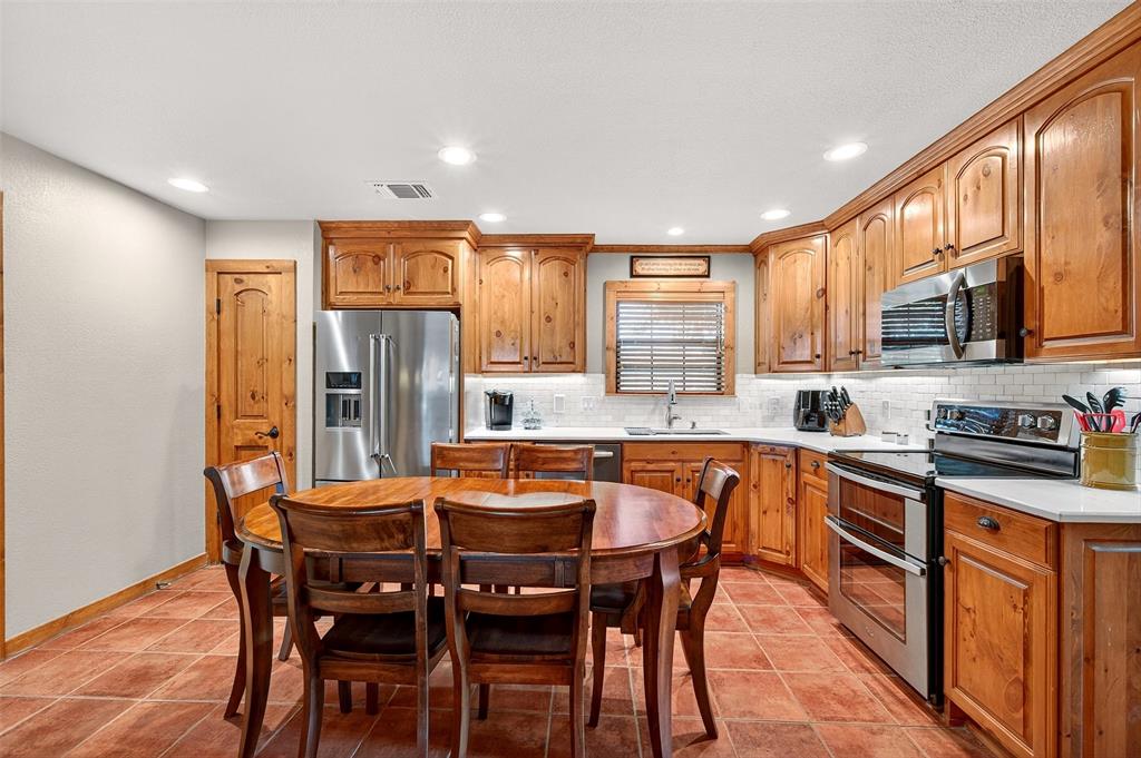 13631 Farm To Market Road 981 Blue Ridge, TX 75424 - Photo 16 of 40 a kitchen with stainless steel appliances kitchen island granite countertop a table chairs sink and cabinets