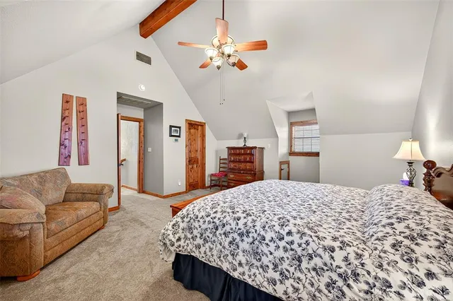 a spacious bedroom with a bed a couch and a chandelier