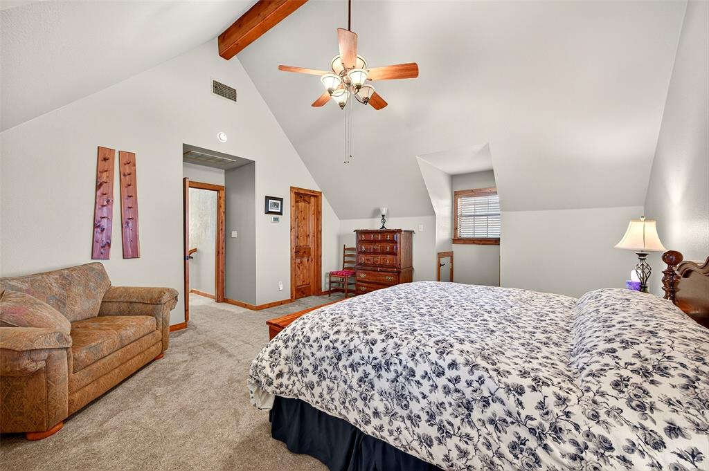 13631 Farm To Market Road 981 Blue Ridge, TX 75424 - Photo 30 of 40 a spacious bedroom with a bed a couch and a chandelier