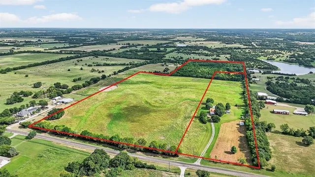 an aerial view of residential houses with outdoor space and trees