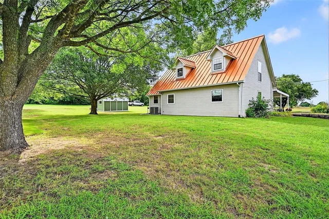 a backyard of a house with table and chairs