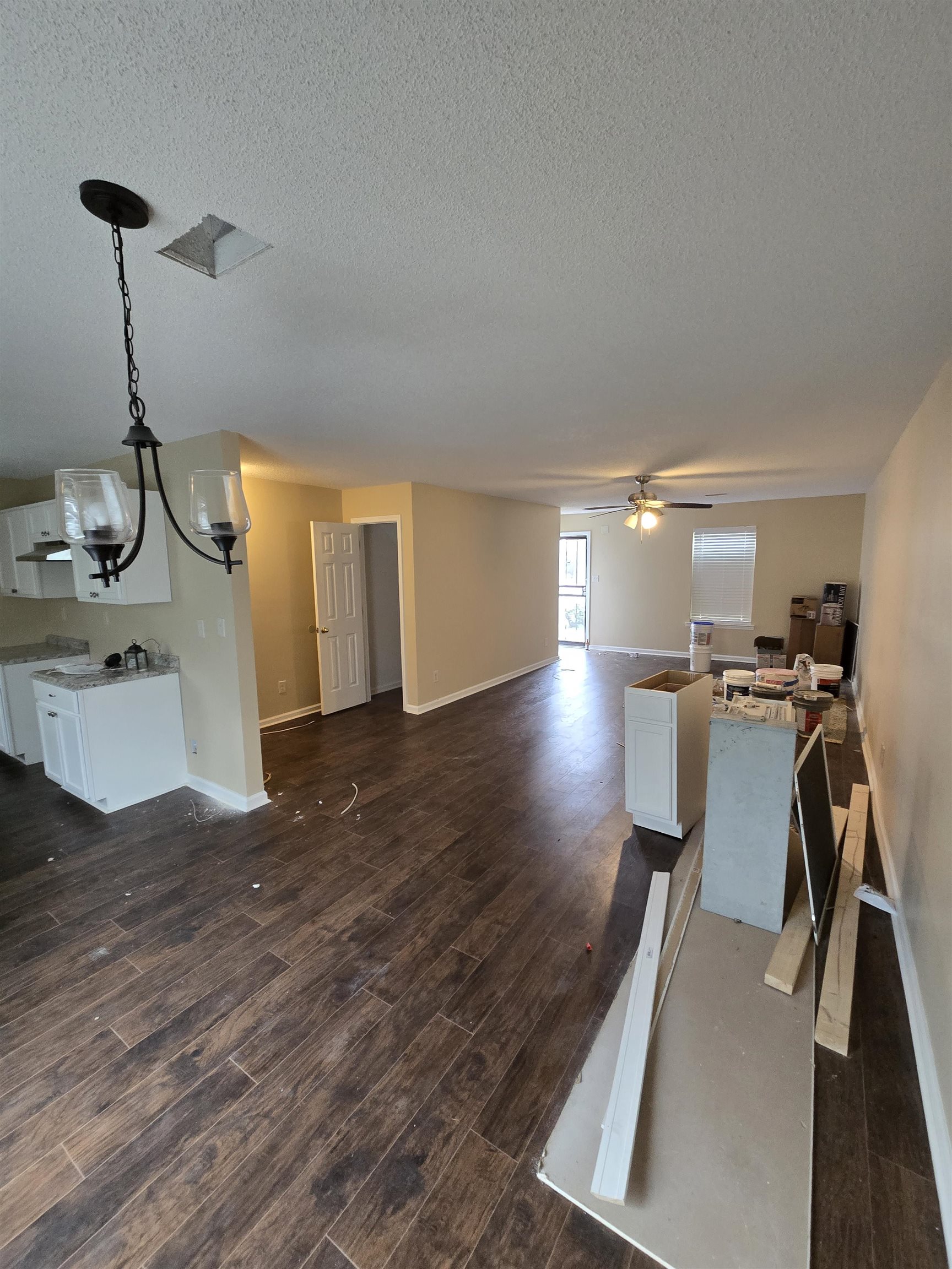 4709 Old Raleigh Millington Road Memphis, TN 38128 - Photo 5 of 7 Living room featuring dark hardwood / wood-style flooring, ceiling fan with notable chandelier, and a textured ceiling