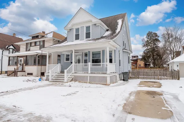 a front view of a house with a yard covered in snow