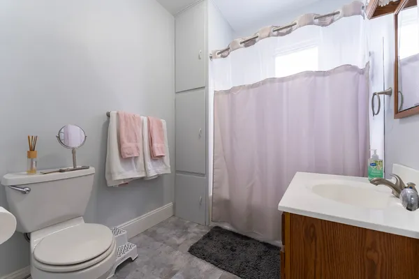 a bathroom with a sink a toilet and shower curtain