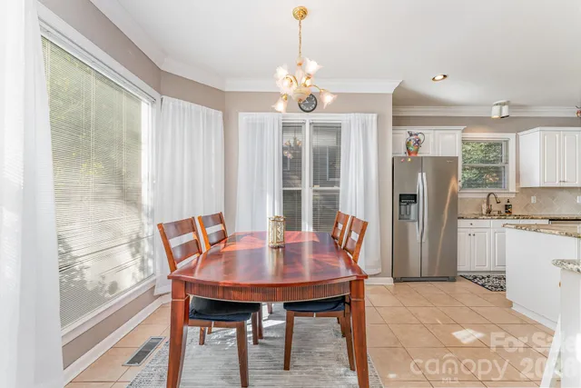 a dining room with furniture a chandelier and wooden floor