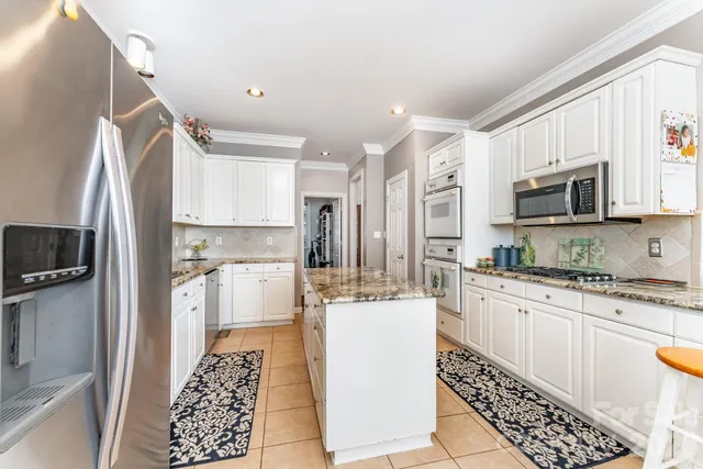 a kitchen with stainless steel appliances a refrigerator sink and microwave