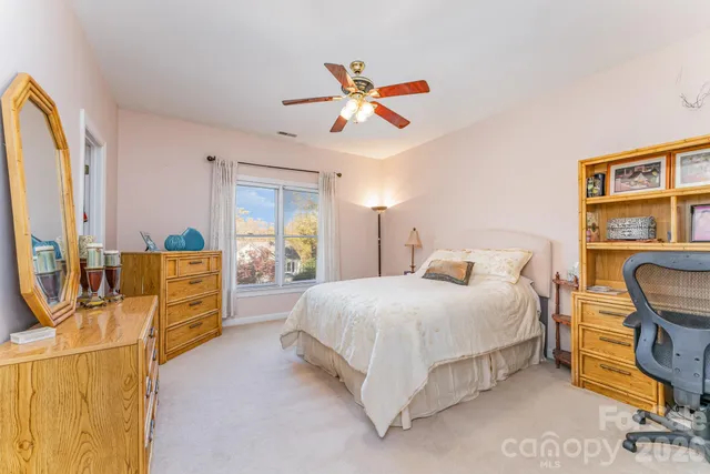 a bedroom with a bed a dresser next to a window