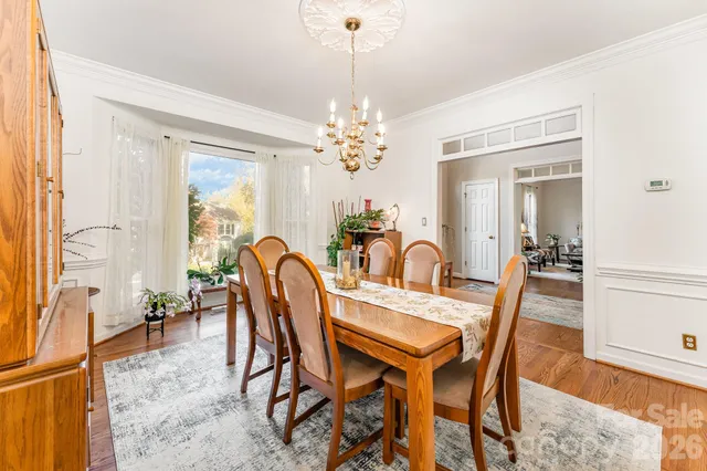 a dining room with furniture a chandelier and wooden floor