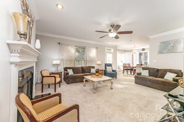 a living room with furniture a fireplace and a chandelier