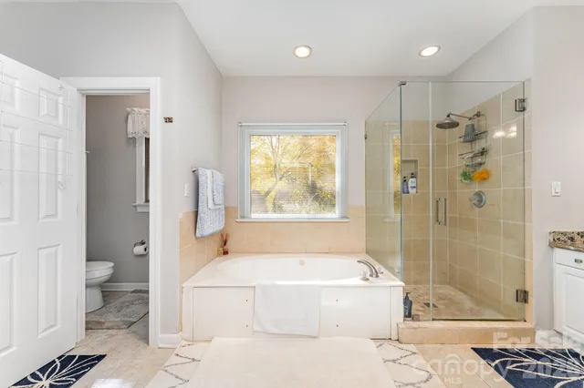 a spacious bathroom with a tub shower and toilet