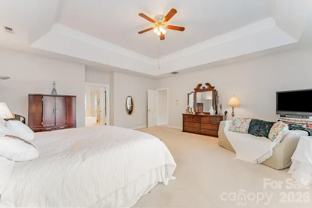 a bedroom with a bed a couch and a flat screen tv