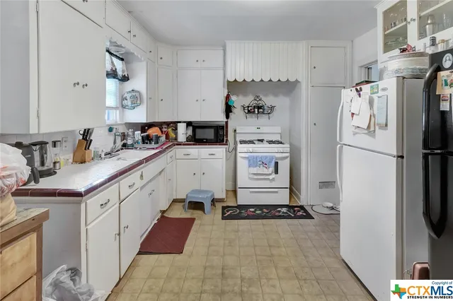 a kitchen with a refrigerator and a sink