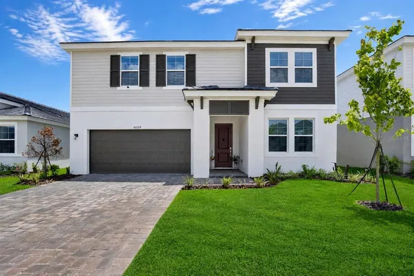 a front view of a house with a yard and garage