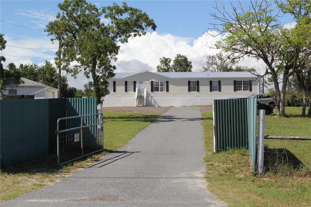 13127 Star Road Brooksville, FL 34613 - Photo 32 of 54 a front view of a house with a garden