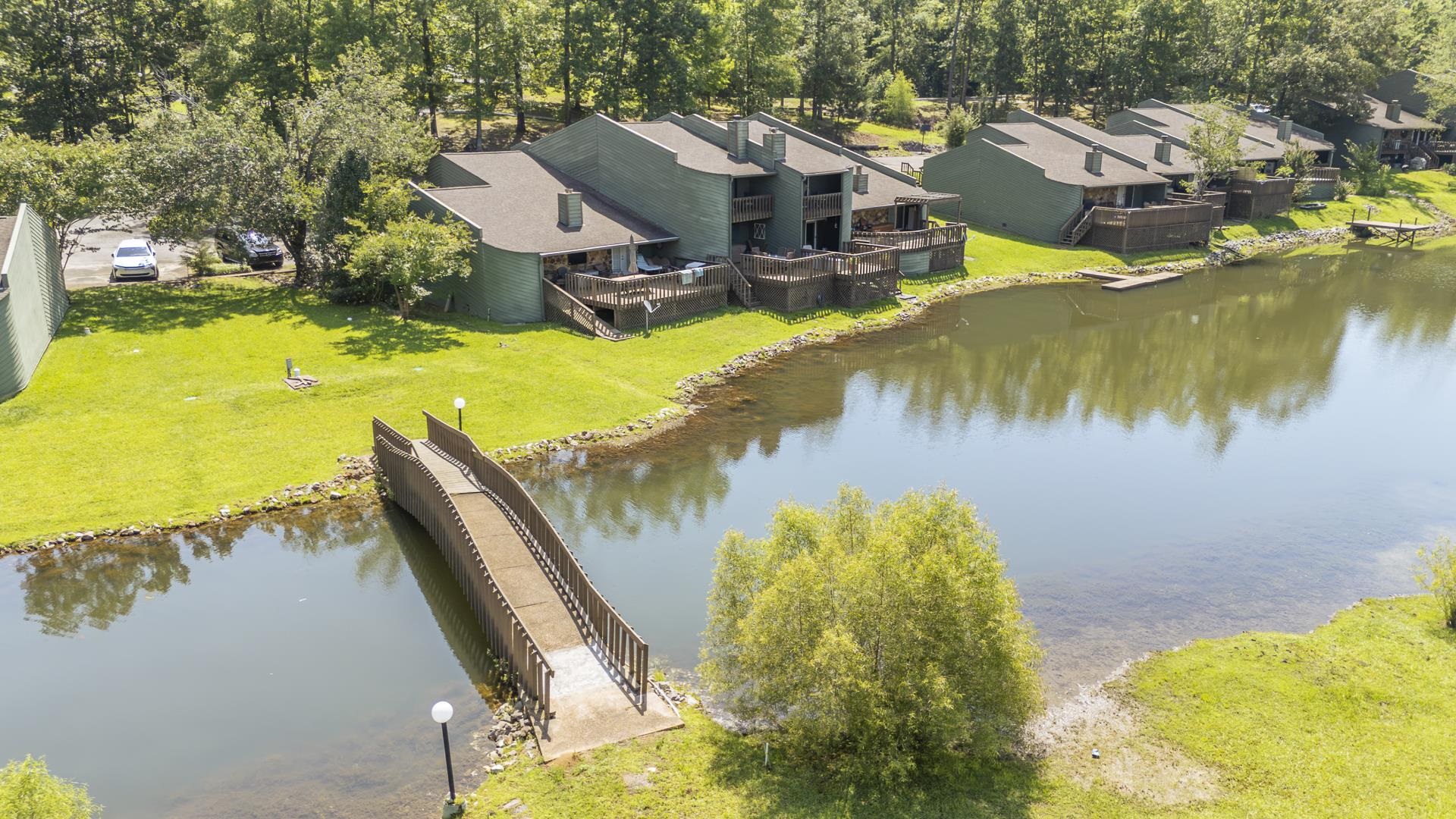 74 Driftwood Road Counce, TN 38326 - Photo 40 of 40 Lakeside multi-story townhomes featuring private decks overlooking the water, individual parking spaces, and a shared pedestrian bridge