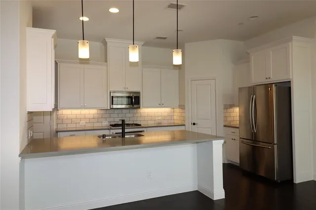 a kitchen with stainless steel appliances a refrigerator a sink and a stove