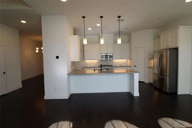 a kitchen with kitchen island white cabinets and stainless steel appliances