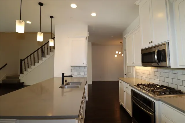 a kitchen with kitchen island a stove and a wooden floor