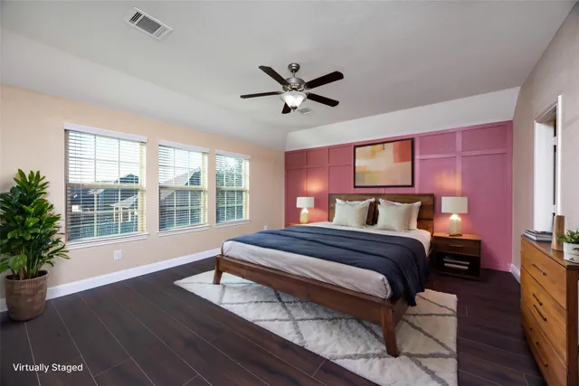 a spacious bedroom with a large bed and a potted plant