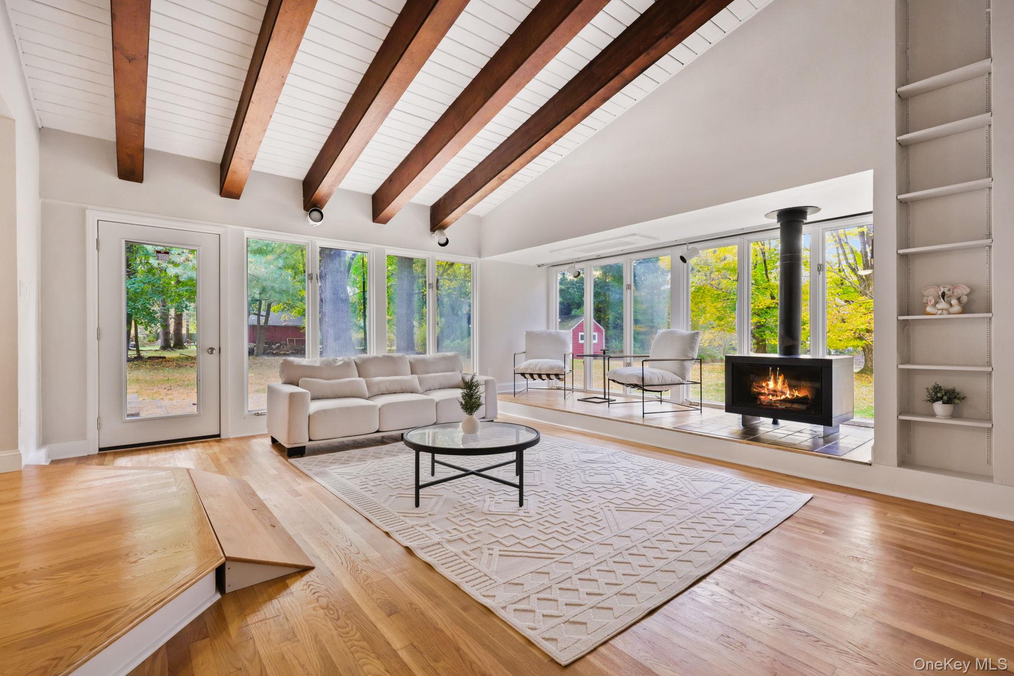 790 Hardscrabble Road Chappaqua, NY 10514 - Photo 19 of 40 Living room with built in features, healthy amount of natural light, hardwood / wood-style flooring, high vaulted ceiling, and beamed ceiling