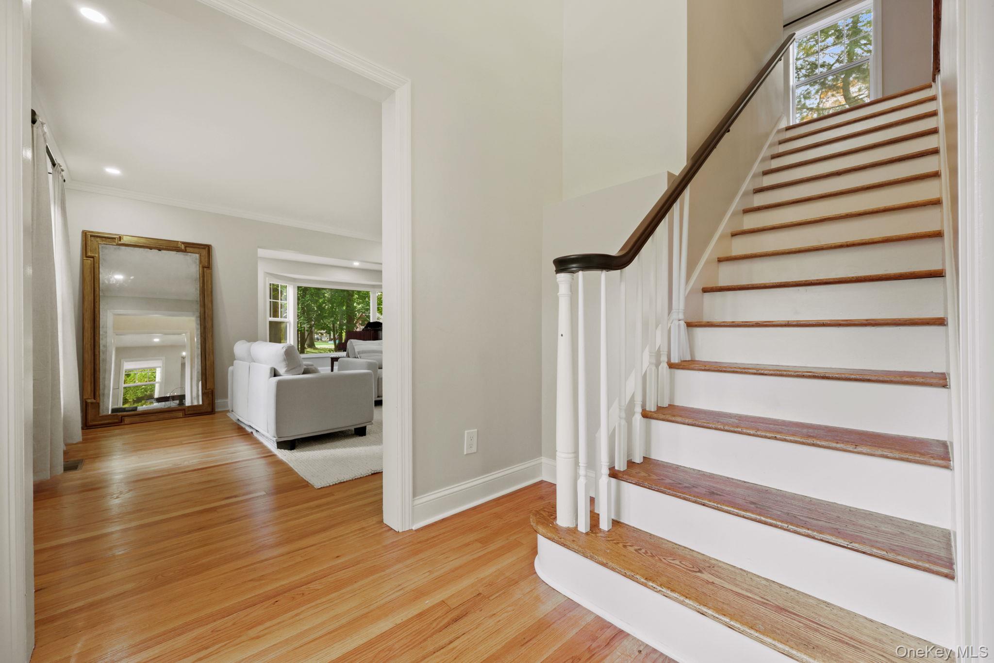 790 Hardscrabble Road Chappaqua, NY 10514 - Photo 5 of 40 Staircase featuring wood finished floors, a barn door, and crown molding