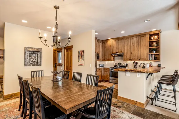 a dining table with chairs and kitchen view