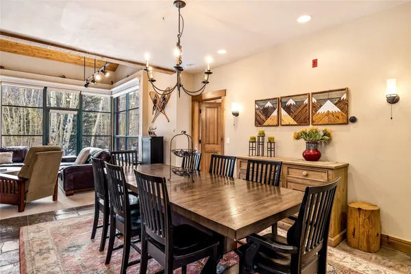 a view of a dining room and livingroom with furniture wooden floor a chandelier