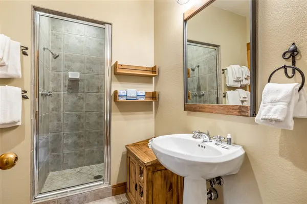 a bathroom with a sink shower and a mirror