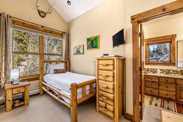 a bedroom with a bed and a flat tv screen on dresser