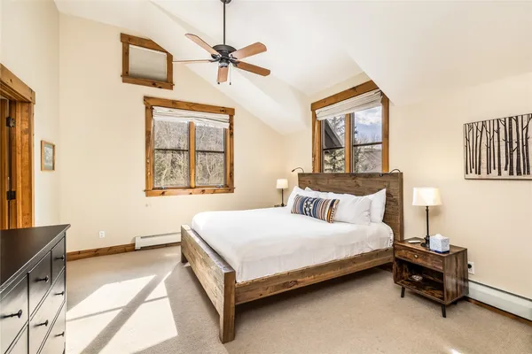 a bedroom with a bed a chandelier and a dresser