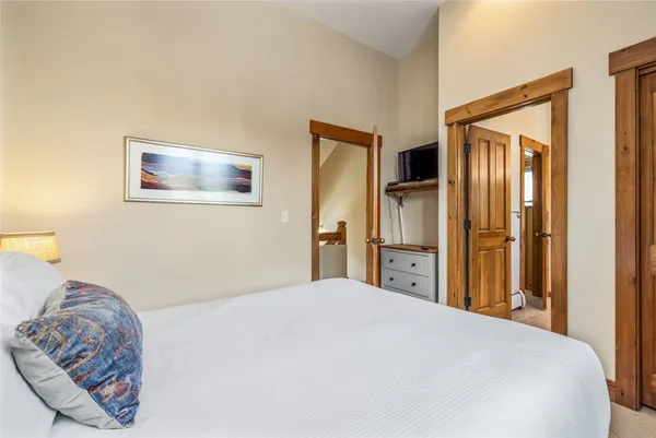 a bedroom with a bed and a painting on the wall