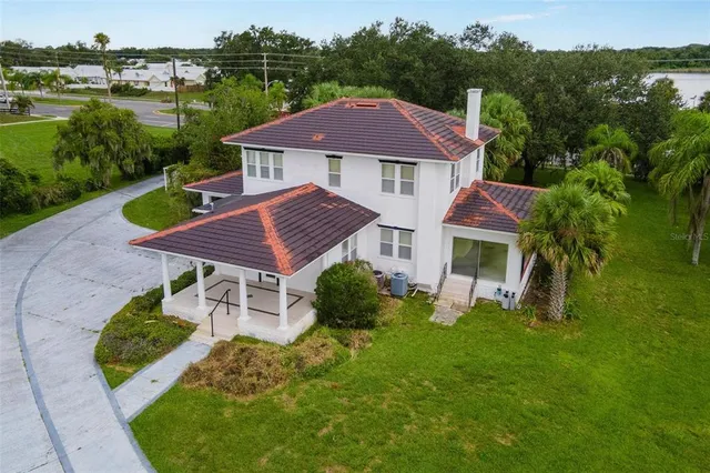 an aerial view of green landscape with trees houses and lake view