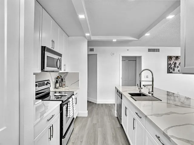 a kitchen with stainless steel appliances granite countertop a sink stove and cabinets