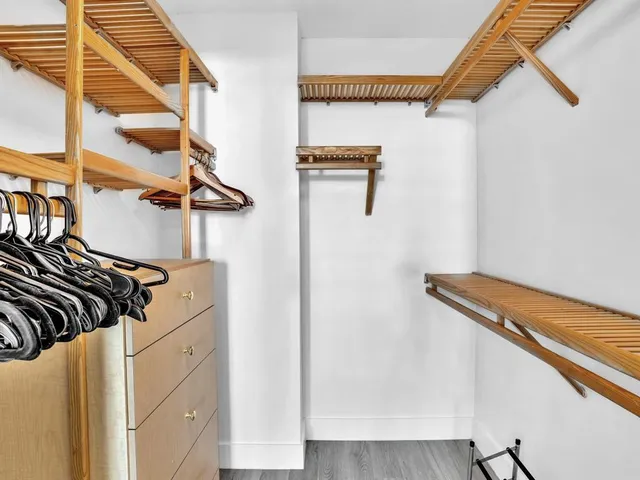 a view of walk in closet with clothes and shoes