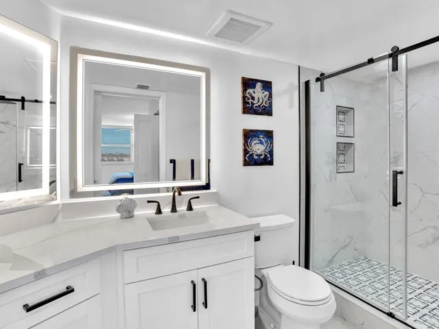 a bathroom with a sink a toilet and shower