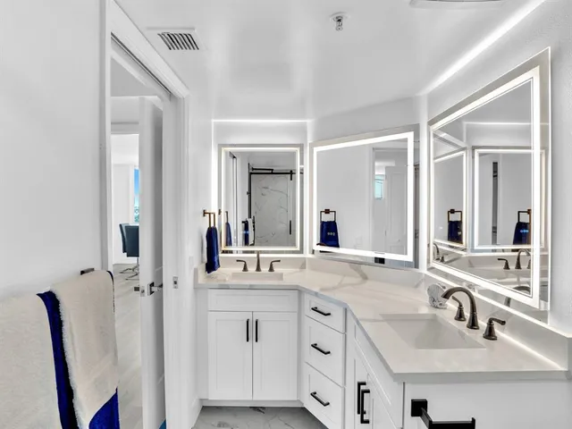 a bathroom with double vanity sink and a mirror