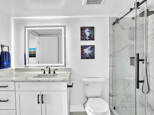 a bathroom with a granite countertop toilet sink and shower