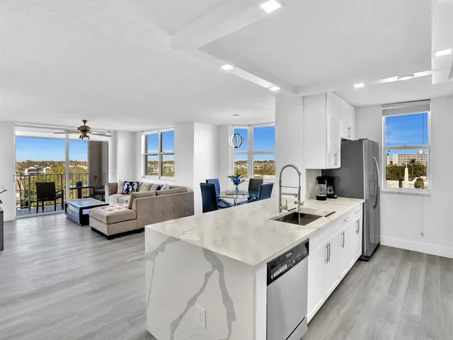 a kitchen with sink a counter top space and living room view