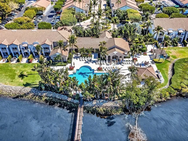 a front view of a house with fountain and tree s