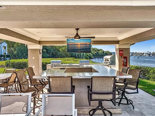 a view of a balcony with wooden chairs and ocean view